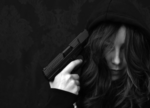 Comportamento suicida - mulher jovem com revolver na cabeça preste a cometer suicídio.